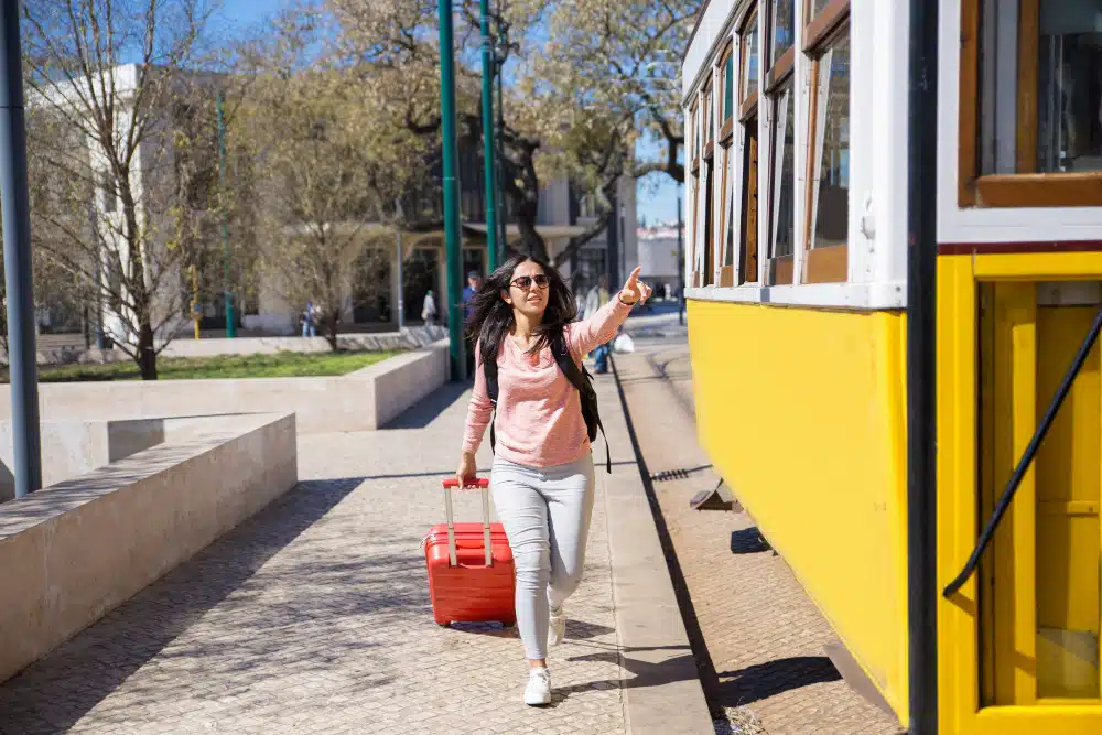 mujer joven corriendo trolebus tirando maleta